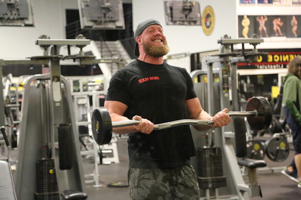 Mathias lifting gym equipment with his hands